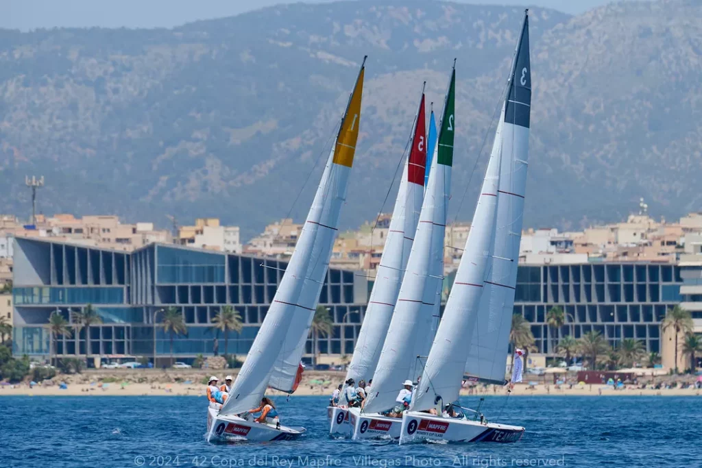 The Women's Cup fleet with the conference centre in the background at the Copa del Rey MAPFRE 
